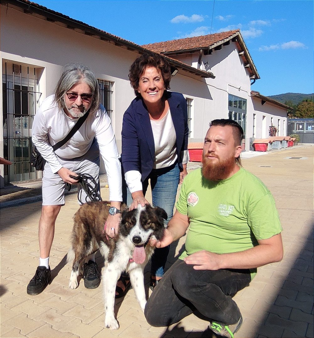 Bubu con la sua nuova famiglia e un volontario davanti al canile